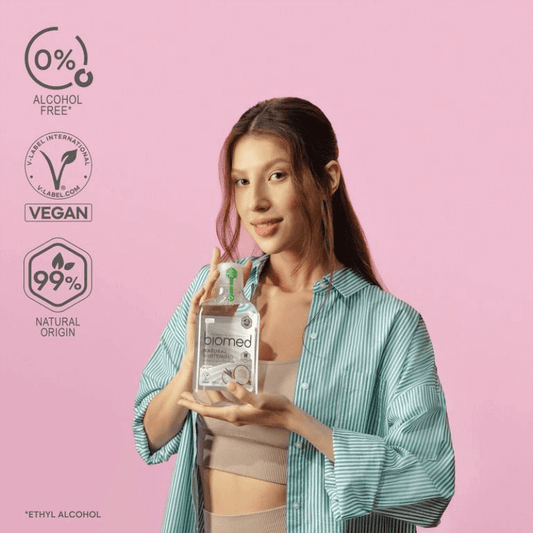 Woman holding organic oral care products in a bottle, promoting a healthier smile with natural ingredients.
